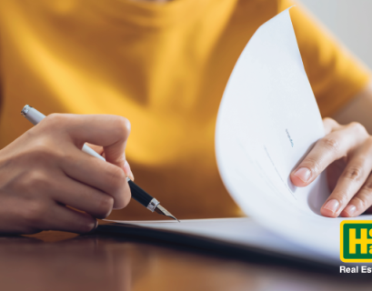 a woman in a yellow top evaluates real estate paperwork