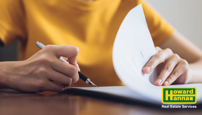 a woman in a yellow top evaluates real estate paperwork